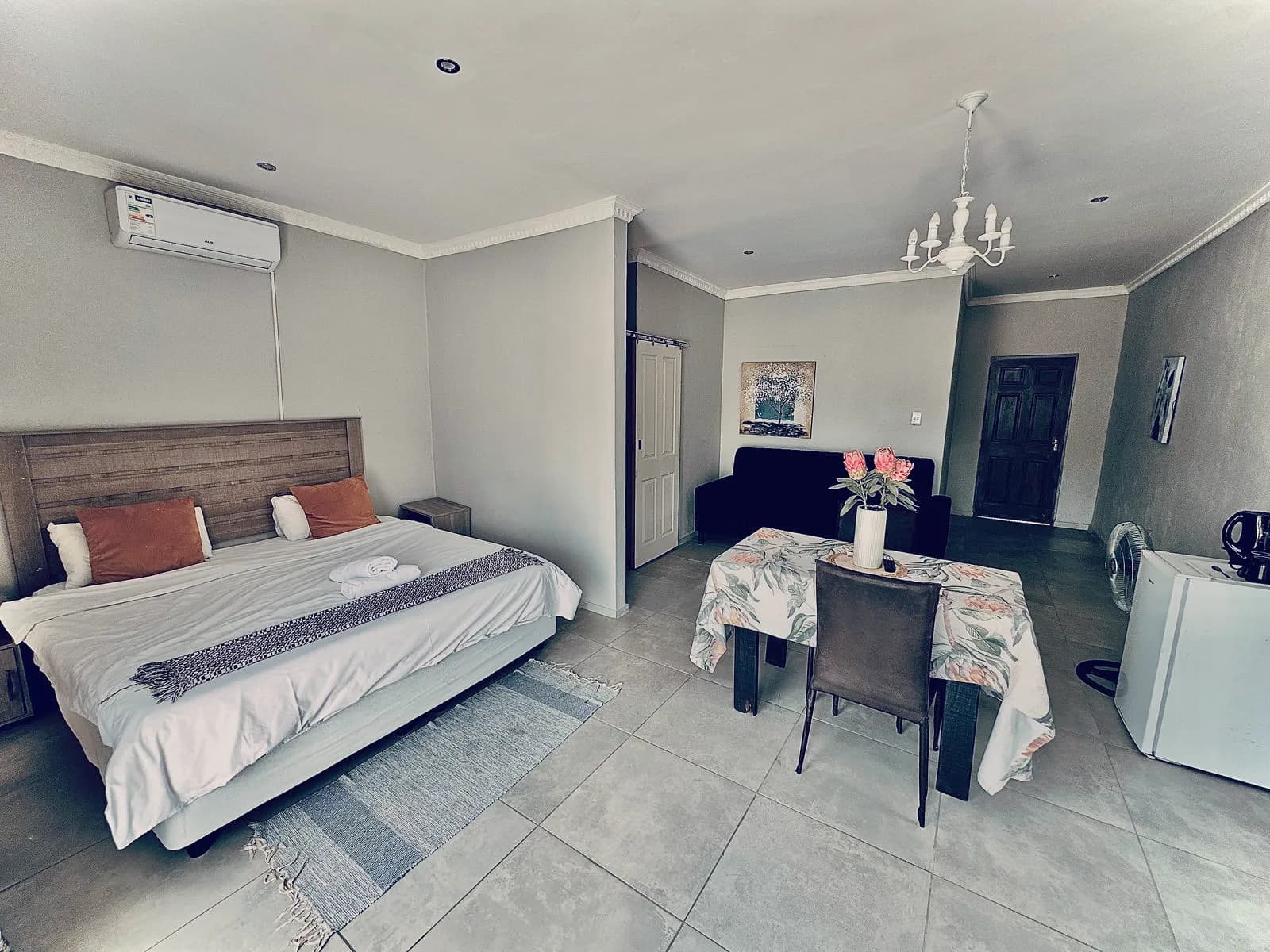 The King Deluxe Room with its bed, dining table and chandelier